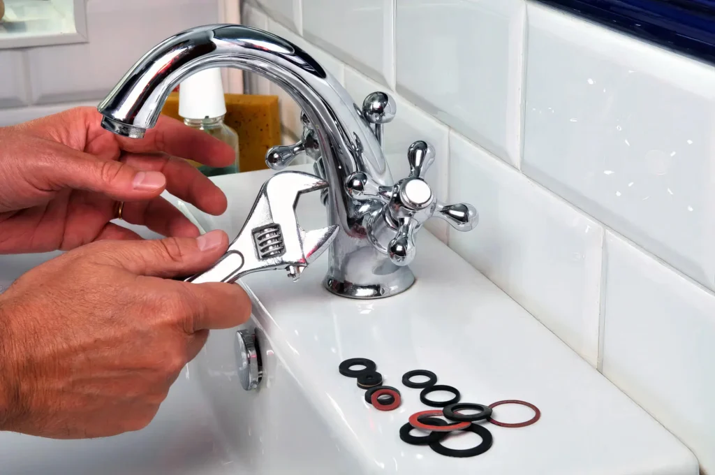 Plumber performing maintenance on a bathroom faucet in Ormond Beach