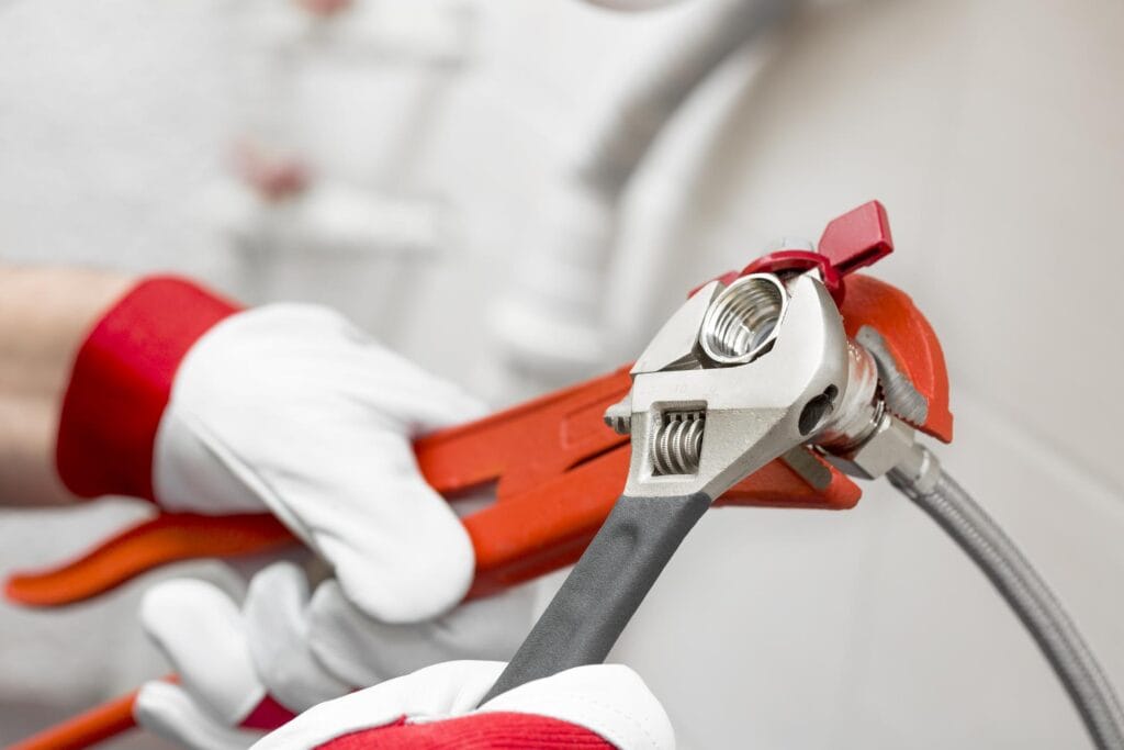 Plumber holding pipe wrenches for an emergency repair in Ormond Beach