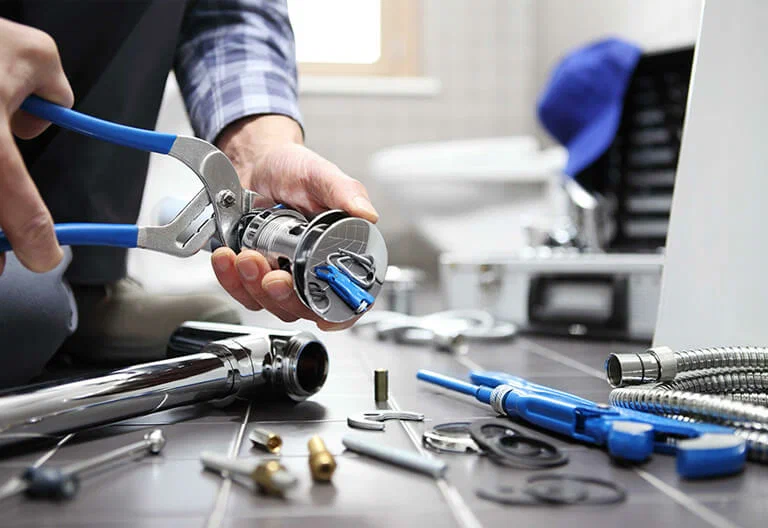 Technician repairing a plumbing fixture with professional tools in Ormond Beach