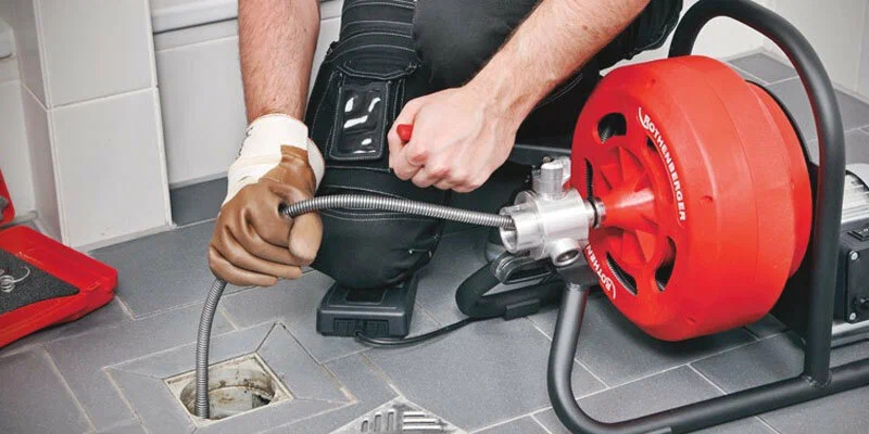 Plumber using a drain-cleaning machine in Ormond Beach