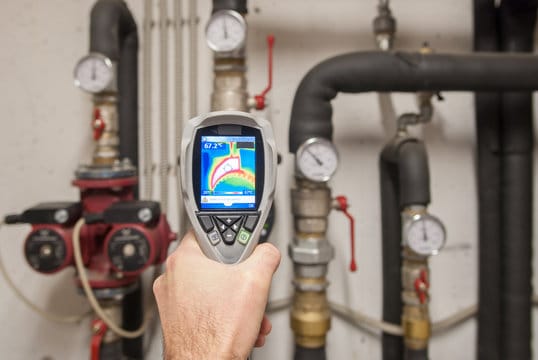 Plumber using a thermal imaging camera to inspect pipes in Ormond Beach
