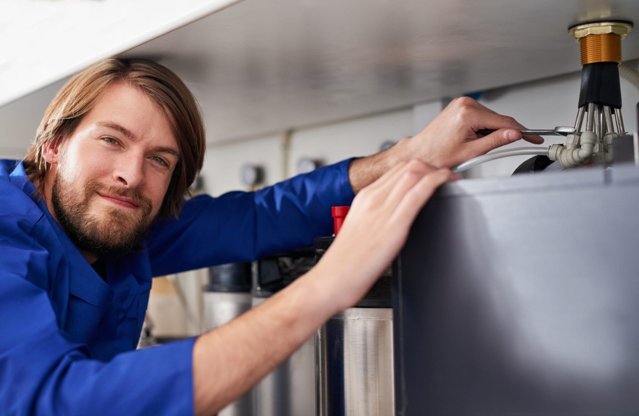 Technician servicing a residential water heater tank in Ormond Beach